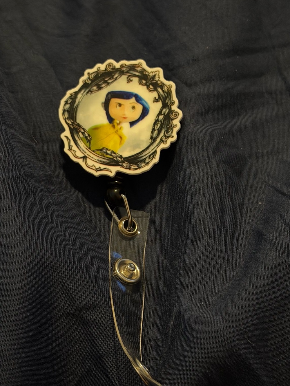 Coraline-Themed Badge Reel with Blue and Yellow Design